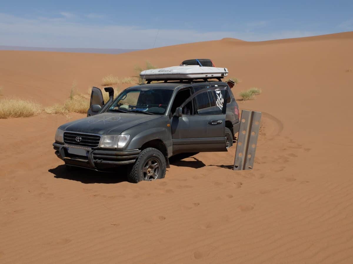 4x4 toyota ensablé dans le désert du Maroc, une plaque de métal est sortie pour désensabler le véhicule
